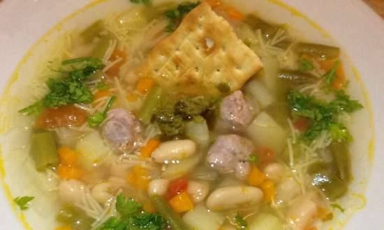 Italian vegetable soup with pasta, sausage meatballs and pesto sauce