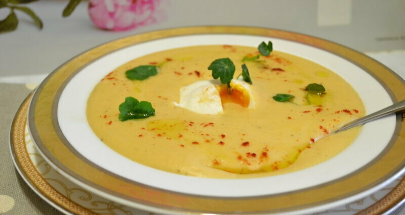Creamy soup with cauliflower, potatoes and poached egg