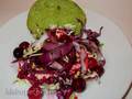 Salad of two types of cabbage with grilled onions under berry sauce on a bun made of aromatic herbs